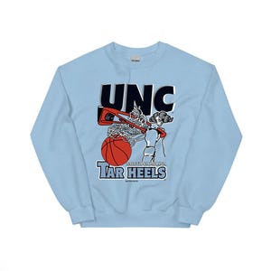 May include: Light blue sweatshirt with a vintage-style graphic of a basketball player dunking. The graphic includes the text "UNC" and "NORTH CAROLINA TAR HEELS".