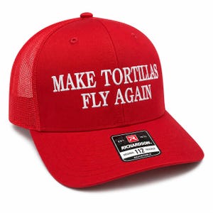 May include: A bright red trucker hat featuring a mesh back and an adjustable strap. The front panel is embroidered with the white text "MAKE TORTILLAS FLY AGAIN" in a bold, capitalized font. A black and white sticker is attached to the brim.