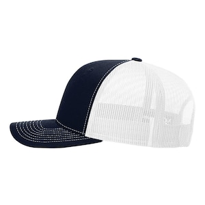 May include: A navy blue baseball cap with a solid front panel and a white mesh back. The cap features a curved brim with white stitching along the edge and a matching navy blue button on the top centre of the crown for a classic structured look.