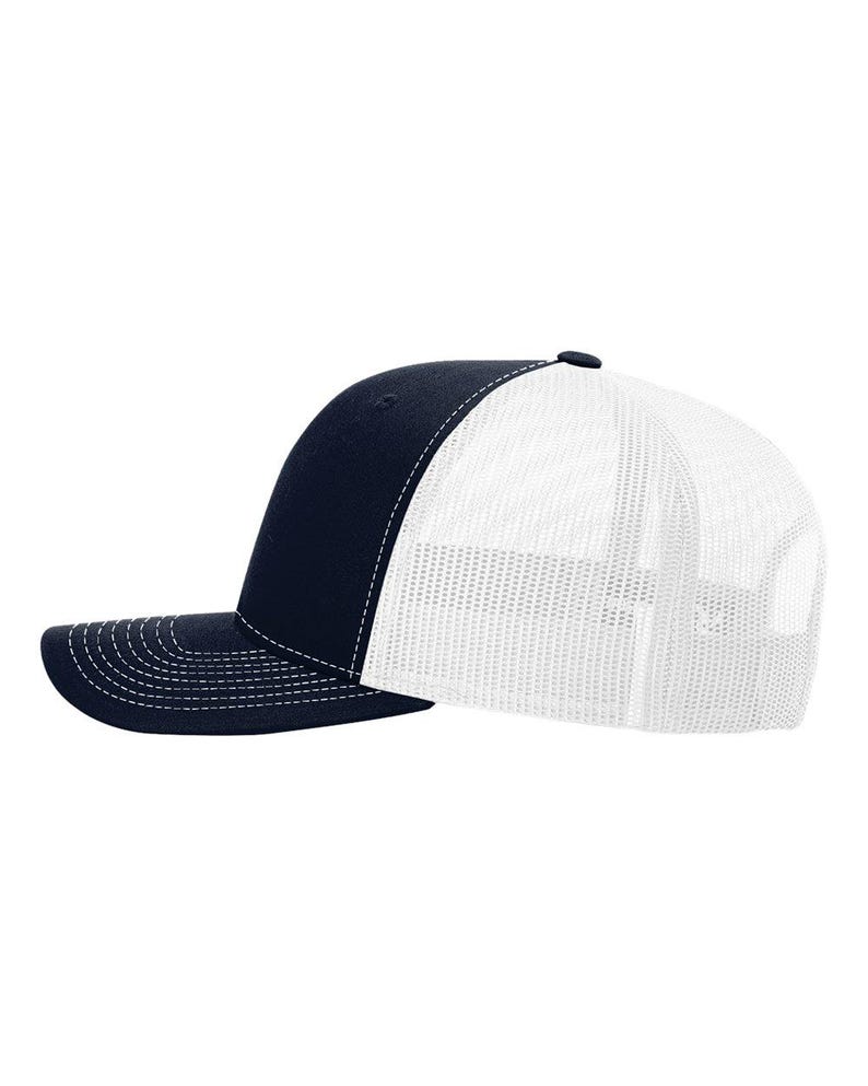May include: A navy blue baseball cap with a solid front panel and a white mesh back. The cap features a curved brim with white stitching along the edge and a matching navy blue button on the top centre of the crown for a classic structured look.