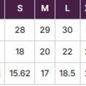 May include: A size chart with measurements for clothing. The chart includes sizes S, M, L, XL, 2XL, and 3XL. Measurements are provided for body length, body width, and sleeve length in inches. The chart has a purple header.