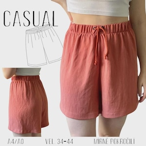 May include: Coral-colored casual shorts with an elastic waistband and drawstring. The shorts have a textured vertical stripe pattern. The word "CASUAL" is printed in black, along with a line drawing of the shorts. The size range is 34-44.