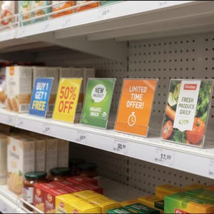 May include: A supermarket shelf displays promotional signs. The signs include "Buy 1 Get 1 Free," "50% Off," "New Product Organic Snack," and "Limited Time Offer!" A sign promotes fresh produce daily with images of vegetables.