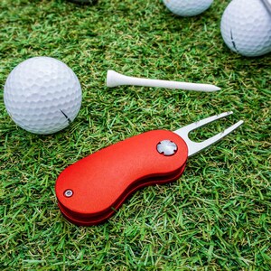Rückansicht des rubinroten Golftools von WOLFSARTIG, präsentiert auf einer Wiese. Die Detailansicht zeigt die hochwertige Verarbeitung und das elegante Design des Tools.