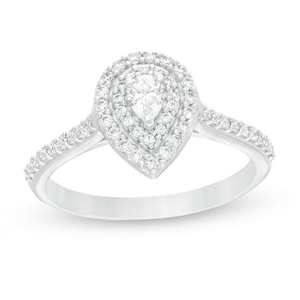 May include: A pear-shaped diamond engagement ring with a halo setting. The ring is set in sterling silver and features a row of smaller diamonds around the band.