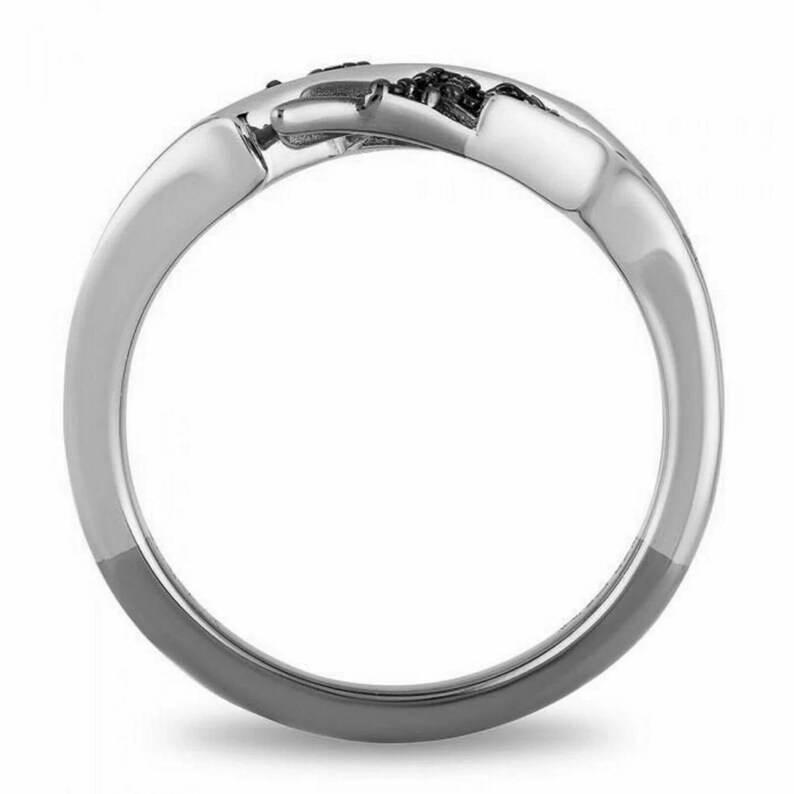 Op de afbeelding: Een zilveren ring met een zwart diamantontwerp. De ring is een eenvoudige band met een twist-ontwerp.