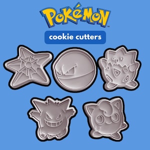K&ouml;nnte beinhalten: Ein Set aus f&uuml;nf hellgrauen Kunststoff-Ausstechformen in verschiedenen Charakterformen, darunter ein Stern, eine Kugel und drei verschiedene Kreaturen. Der Text Pok&eacute;mon cookie cutters ist in Blau und Gelb &uuml;ber den Formen abgebildet.
