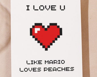 May include: A white greeting card with the text "I LOVE U" in pixelated black letters. Below is a pixelated red heart, and the text "LIKE MARIO LOVES PEACHES" in black pixelated letters.