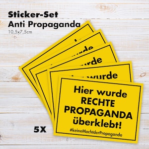 Könnte beinhalten: Ein Satz von fünf gelben Aufklebern mit schwarzen Rändern. Die Aufkleber tragen den Text "Hier wurde RECHTE PROPAGANDA überklebt!" und "#keineMachtderPropaganda". Jeder Aufkleber misst 10,5 x 7,5 cm.
