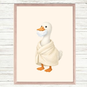 Puede incluir: Impresión enmarcada que presenta una ilustración de un ganso blanco con pies naranjas, que lleva una bata blanca y una barba esponjosa. El fondo es de color beige claro y la obra de arte está enmarcada en un marco marrón claro.