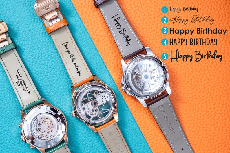 May include: Three automatic watches with visible internal mechanisms and leather straps. The straps are in various colors, including green, orange, and brown. Text on the straps includes "Happy Birthday" and "I love you till the end of time."