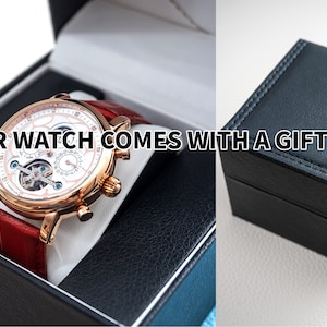 Pu&ograve; includere: Un orologio dorato con quadrante bianco e cinturino in pelle rossa viene fornito in una scatola regalo nera. "Your watch comes with a gift box" &egrave; scritto sull'immagine.