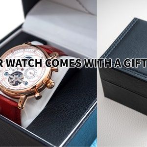 May include: A gold-tone watch with a white face and red leather strap comes in a black gift box. "Your watch comes with a gift box" is written on the image.