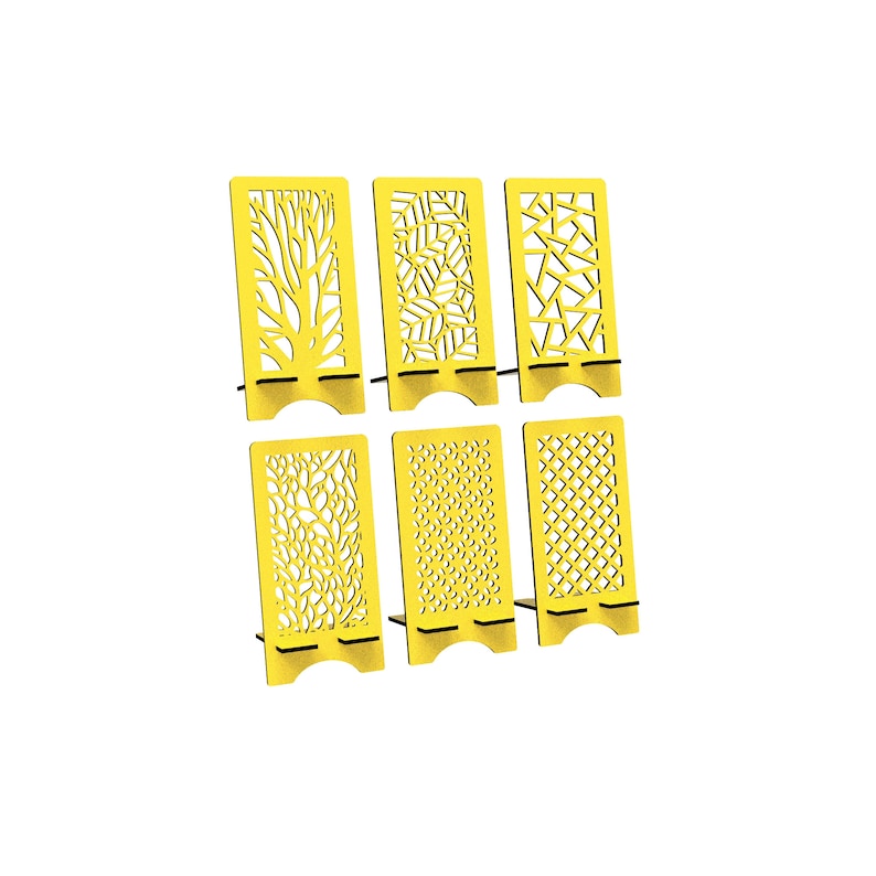 May include: A set of six bright yellow rectangular phone stands, each featuring a unique laser-cut pattern including tree branches, leaves, geometric shapes, and floral motifs. Each stand has a sturdy base with a curved cutout at the bottom.