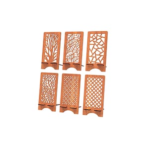 May include: A set of six rectangular wooden phone stands, each featuring a unique laser-cut pattern including tree branches, leaves, geometric shapes, floral motifs, and a lattice grid design, all constructed from a medium-toned brown wood.