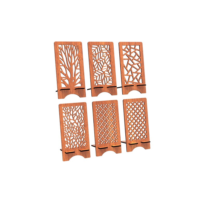 May include: A set of six rectangular brown wooden phone stands, each featuring a unique laser-cut pattern including tree branches, leaves, geometric shapes, and floral motifs. Each stand has a base support ledge and a curved cutout at the bottom.