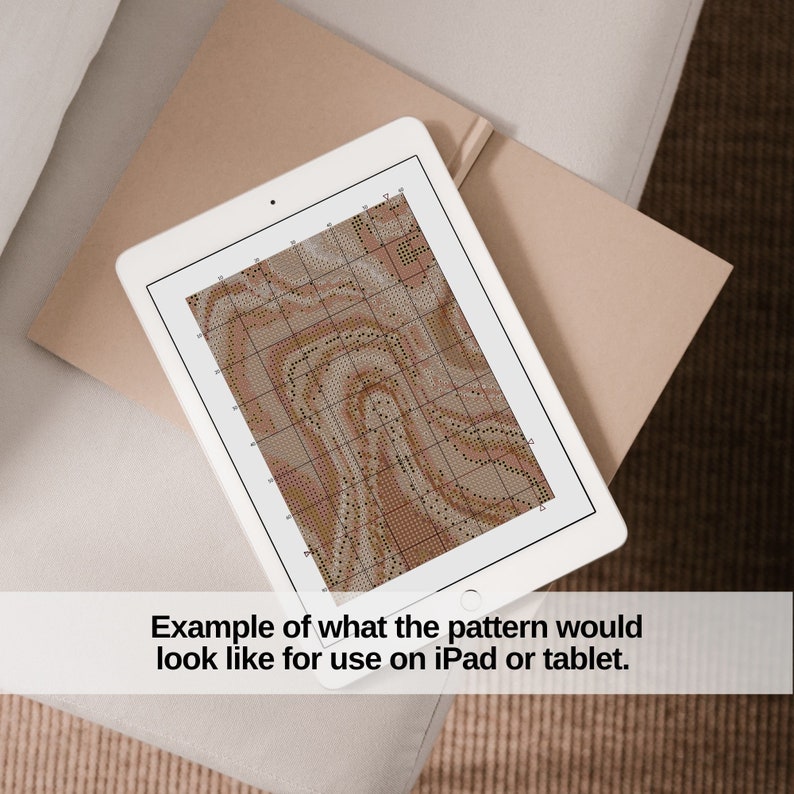 May include: A white tablet showing a cross-stitch design in brown and beige hues. The text at the bottom says, "Example of what the pattern would look like for use on iPad or tablet."