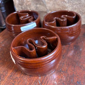 Puede incluir: Tres cuencos de cerámica marrón con un diseño ondulado en el interior. Los cuencos están hechos a mano y tienen una etiqueta que dice "Handmade Pottery by West Virginia".