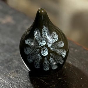 以下が含まれることがあります： 白い花柄のダークグリーンのセラミック製のボトルストッパー。ボトルストッパーは涙の形をしています。