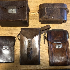 Cinq étuis en cuir vintage des années 30 à 50, dont Kodak, Zeiss et Ensign