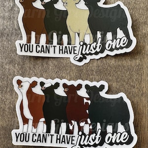 May include: Two stickers featuring a row of cartoon cows in various colors, including brown, black, and tan. The text "YOU CAN'T HAVE just one" is printed on each sticker. The bottom sticker also includes the text "Farm Girl Designs."