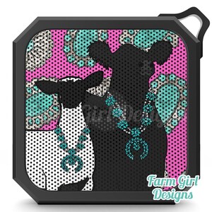 May include: Black portable speaker with a decorative design featuring two cow silhouettes wearing turquoise necklaces against a pink polka dot background. The speaker has a black frame and the text "Farm Girl Designs".