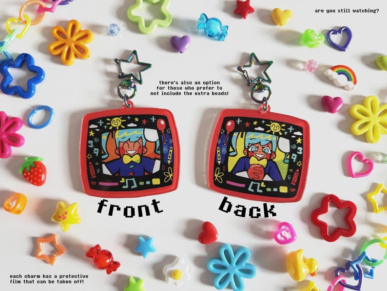 May include: Two red, square-shaped keychains with cartoon illustrations, labeled "front" and "back", are displayed. The keychains are surrounded by colorful plastic charms, including stars, flowers, and hearts. The text "are you still watching?" is visible.