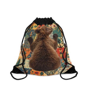 May include: A brown drawstring bag with a colourful forest design and a brown bear cub. The bear is facing away with its arms raised. The bag has black drawstrings and a black top.