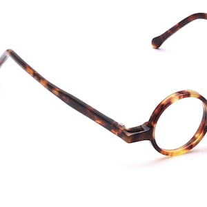 Peut inclure: Lunettes rondes en écaille de tortue avec des verres transparents.