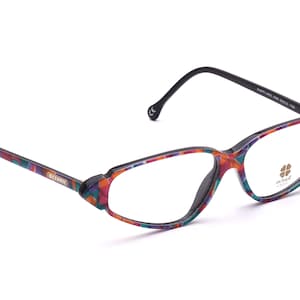 Könnte beinhalten: Bunte, gemusterte Brille mit schwarzen Bügeln und klaren Gläsern. Der Markenname "Oh! France" ist auf dem rechten Glas aufgedruckt.