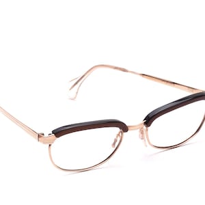 Può includere: Occhiali in metallo dorato con montatura in plastica marrone e lenti trasparenti.