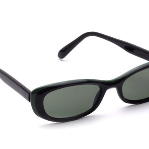 Könnte beinhalten: Schwarze Sonnenbrille mit grünen Rahmen und Gläsern.