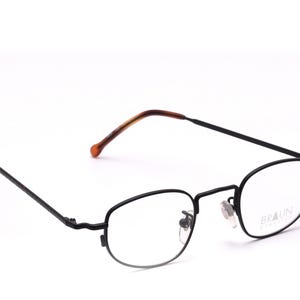 Könnte beinhalten: Schwarze Metallgestellbrille mit klaren Gläsern. Der Markenname "BRAUN" ist auf der rechten Linse aufgedruckt.