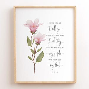 May include: A framed wall art print featuring a watercolour illustration of a pink flower stem with green leaves on the left side. The text on the right reads: WHERE YOU GO I will go AND WHERE YOU STAY I will stay YOUR PEOPLE WILL BE my people AND YOUR GOD my God RUTH 1:16.