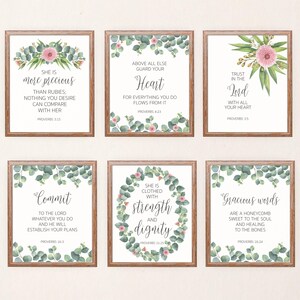 May include: Six framed art prints with inspirational quotes. Each print features botanical elements like eucalyptus leaves and pink flowers. The quotes are in elegant script, with the Bible verse references at the bottom.
