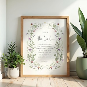 May include: A framed wall art print featuring the text "TRUST IN the Lord WITH ALL YOUR HEART AND DO NOT LEAN ON YOUR OWN UNDERSTANDING. IN ALL YOUR WAYS ACKNOWLEDGE HIM, AND HE WILL MAKE YOUR PATHS STRAIGHT PROVERBS 3:5-6" surrounded by floral vines.