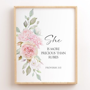 Könnte beinhalten: Ein Aquarelldruck mit einem floralen Design mit rosa Rosen und weißen Blumen. Der Druck hat den Text "She is more precious than rubies Proverbs 3:15".