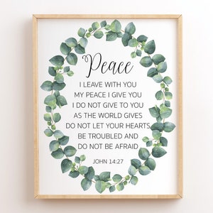 May include: A printable wall art print featuring a green eucalyptus wreath and the text "Peace" in a cursive font. The text below the wreath reads "I leave with you my peace I give you I do not give to you as the world gives Do not let your hearts be troubled and do not be afraid John 14:27".
