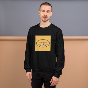 Könnte beinhalten: Schwarzer Pullover mit einem gelben Quadrat, auf dem sich ein marineblauer Kreis mit dem Text "dings apparel" und ein Tennisschläger-Symbol befinden.