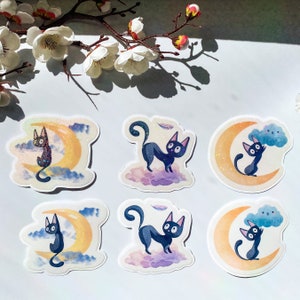 May include: Set of six stickers featuring black cats with crescent moons and clouds. The cats are in various poses, some with stars and feathers. The stickers are printed on white glossy paper.