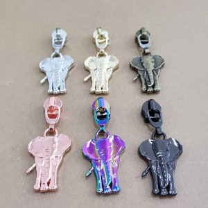 May include: Six zipper pulls with elephant designs in different colors, including silver, gold, bronze, rose gold, iridescent, and black.