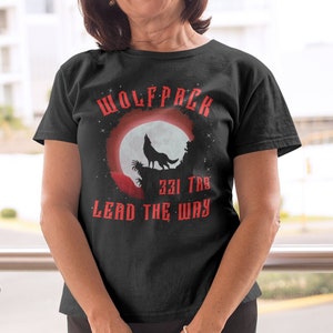 May include: Black t-shirt with a red wolfpack graphic. The graphic features a wolf howling at the moon with the text "Wolfpack 231 The Lead The Way".