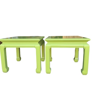 May include: Two lime green square side tables. Each table has a square top and four curved legs. The tables are painted in a solid, bright green color. The tables are a matching set.