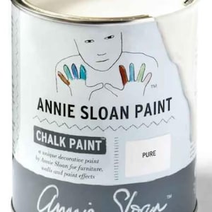 May include: A white can of Annie Sloan Chalk Paint in the color Pure. The can features a hand-painted illustration of a person with colorful hands and the text "Annie Sloan Paint" and "Chalk Paint".