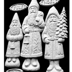 May include: Three white, carved-style figurines of bearded figures in long coats and hats, standing on textured bases. One holds a lantern and sack, another a tree. Three oval plaques are included, featuring the embossed text YULE, NOEL, and JOIE.
