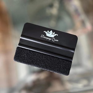 May include: Black squeegee with a felt edge and a white crown logo that says "Decoupage Queen".