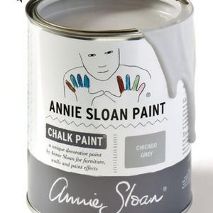May include: A white paint can with a gray lid. The can is labeled "Annie Sloan Paint Chalk Paint" and "Chicago Grey".
