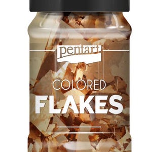 May include: A clear glass jar with a black lid filled with brown and tan colored flakes. The jar has a white label with the brand name "pentart" and the words "COLORED FLAKES" in large, bold letters.