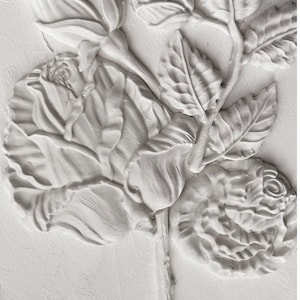 May include: A white plaster relief sculpture of a rose with leaves and buds. The sculpture is detailed and realistic.