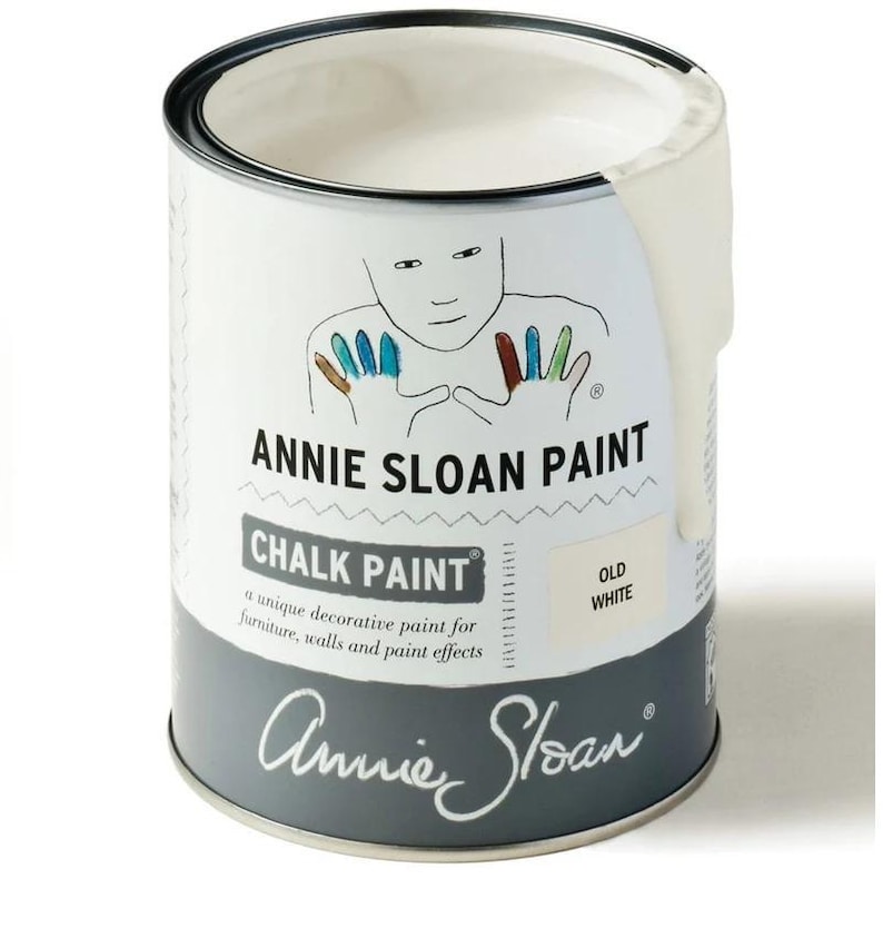 May include: A white can of Annie Sloan Chalk Paint in the color Old White. The can features a whimsical illustration of a person with colorful fingertips and the brand name.